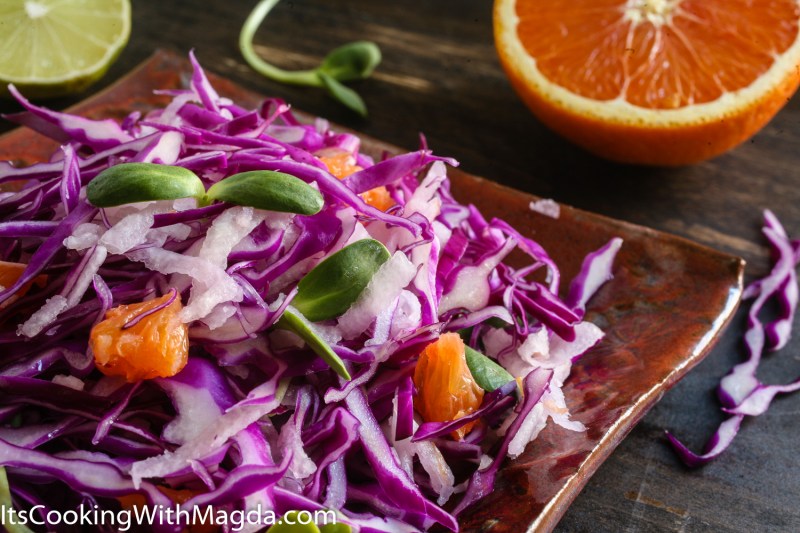 red cabbage jicama salad with cara cara orange on a square plate