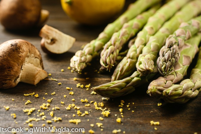 asparagus, mushrooms and grated lemo zest on a board