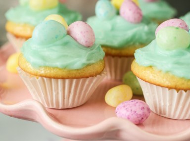 lemon cupcakes with jelly beans on a pink cake stand