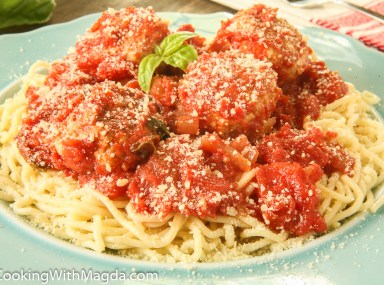 spaghetti with turkey meatballs and cheese on a blue plate