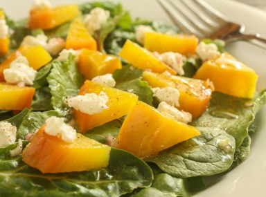 roasted golden beets on a bed of mixed greens with goat cheese