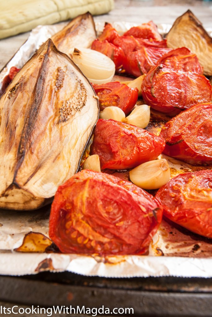 roasted eggplant, tomatoes and garlic on a baking pan