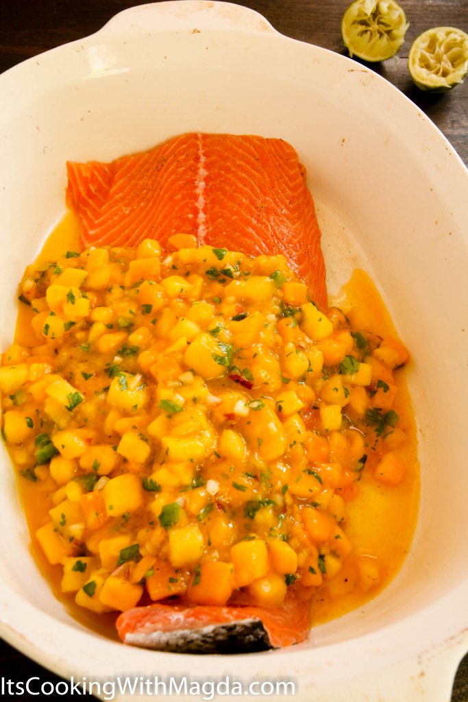 salmon fillet in a baking dish with mango salsa