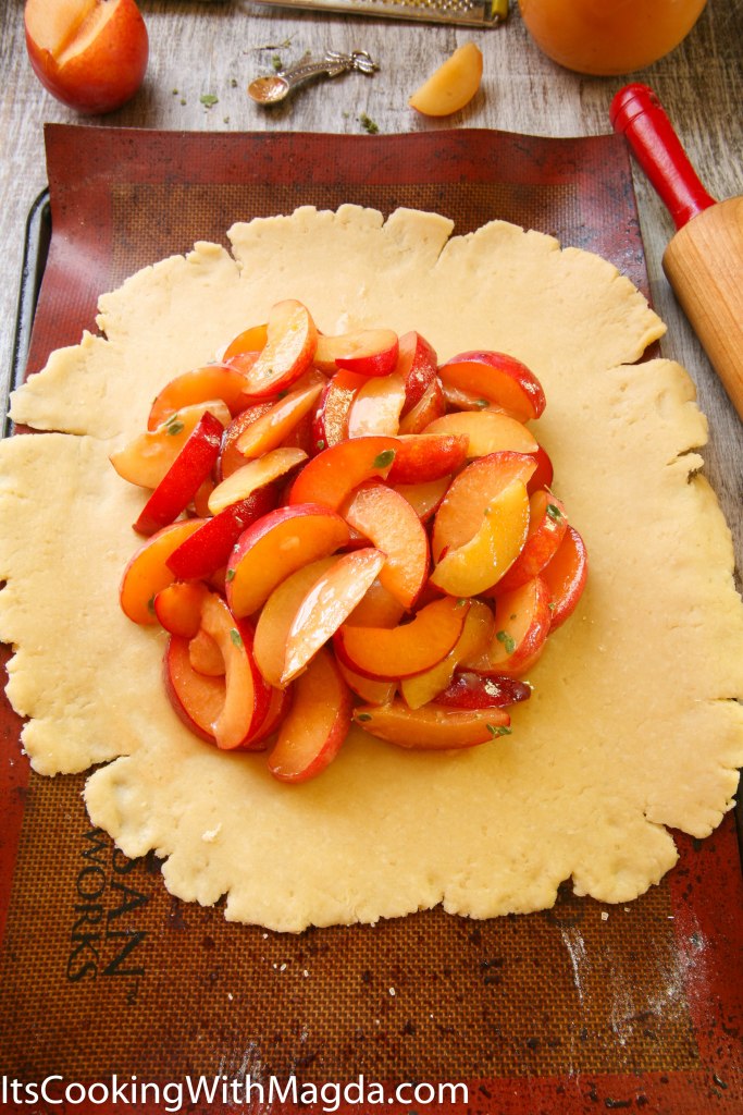 Sliced plums in the center of the rolled out dough