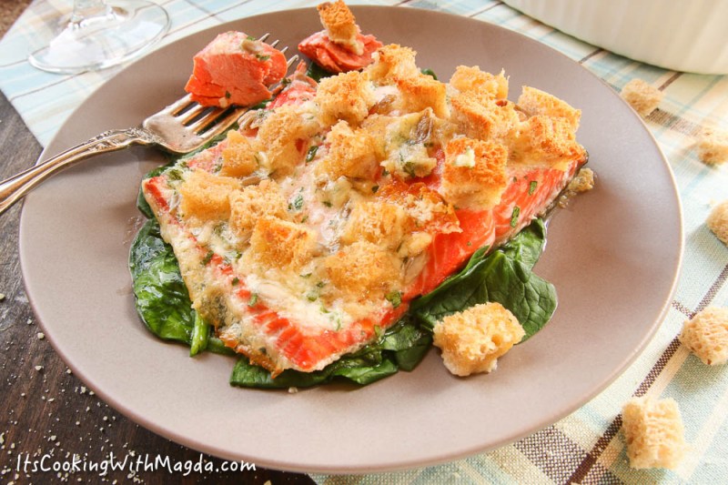 baked salmon with croutons on a bed of sauteed spinach