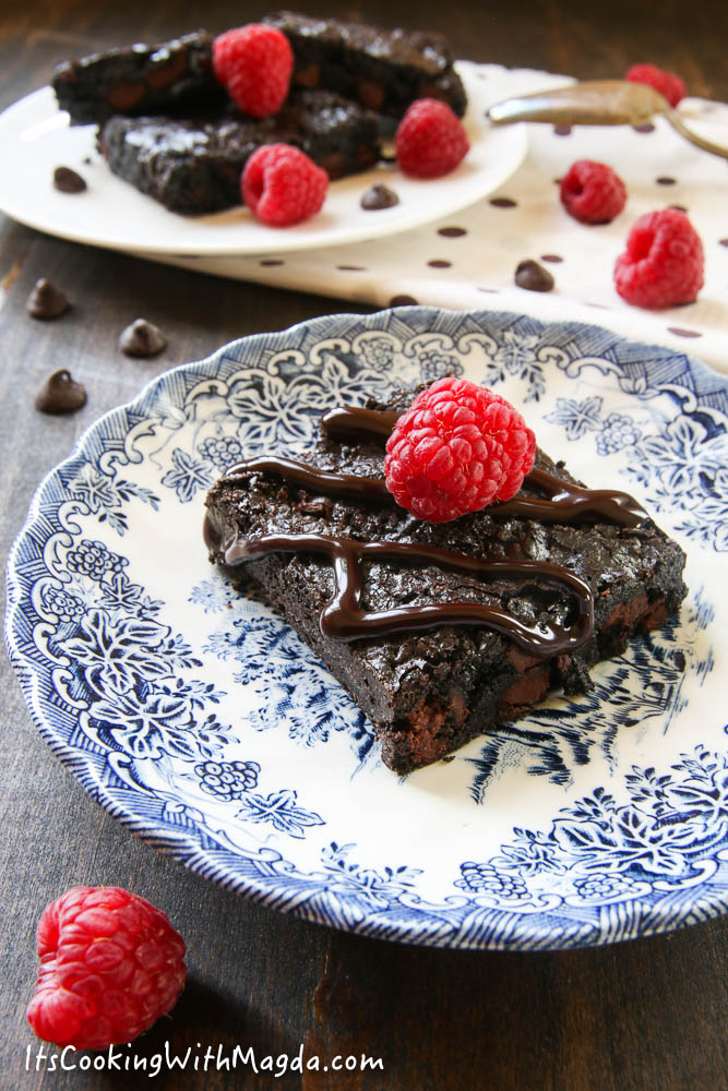 brownie on a blue plate with raspberries